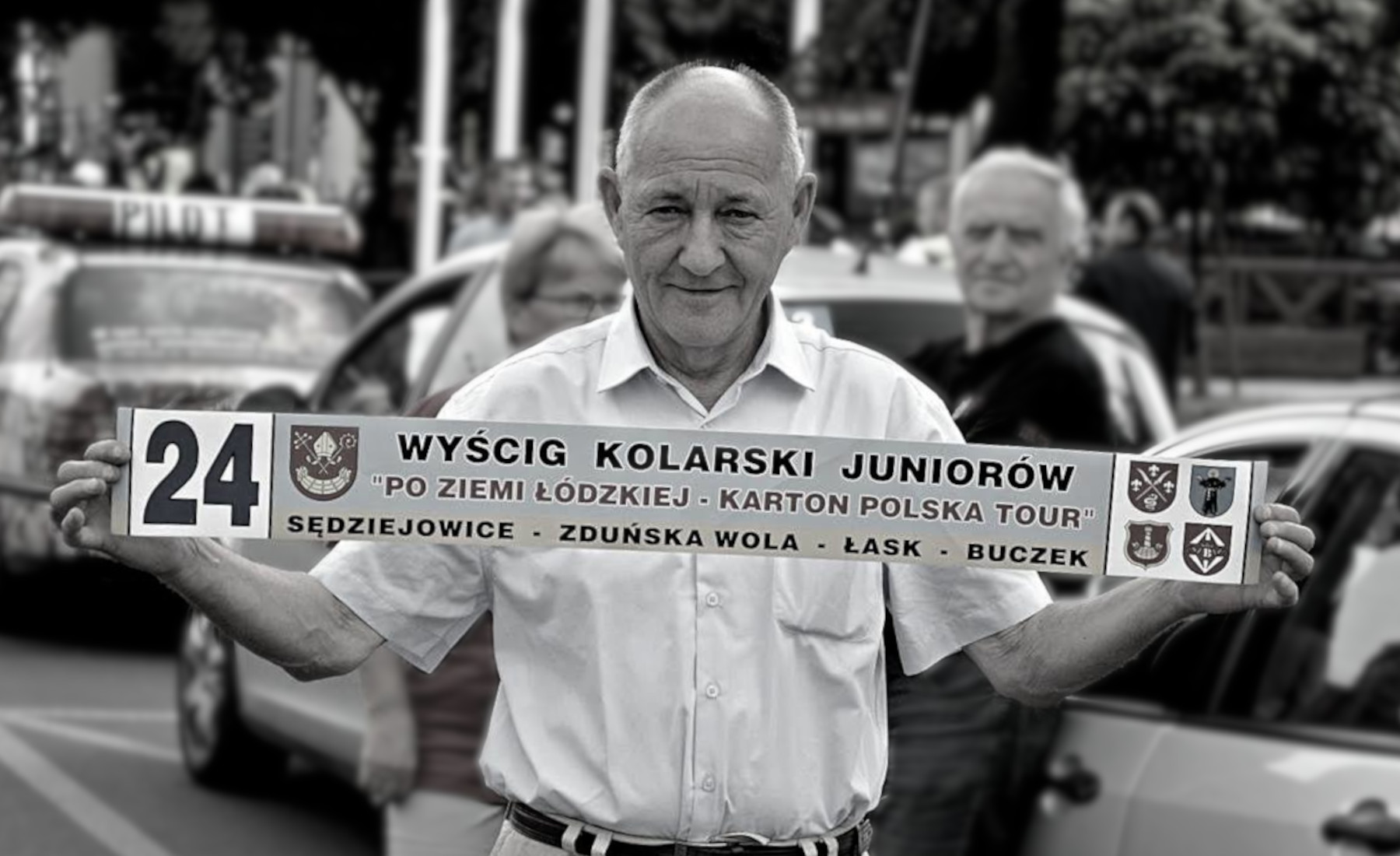 Andrzej Syska trzymający szarfę wyścigu kolarskiego