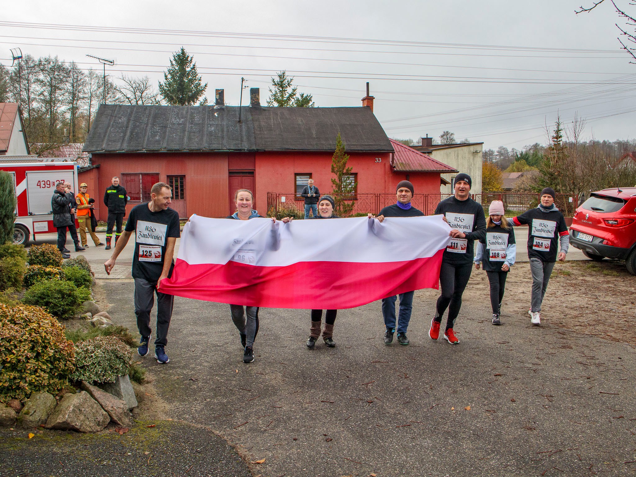 Biegacze z biało-czerwoną flagą